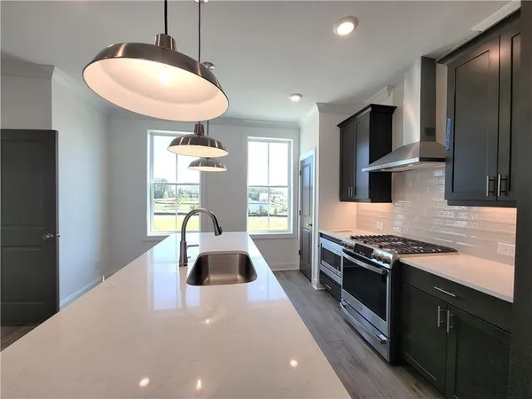 a kitchen with stainless steel appliances a stove a sink and a refrigerator