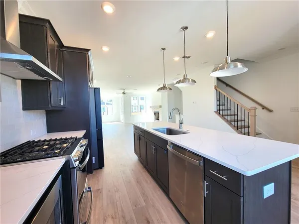 a kitchen with kitchen island a sink stove and wooden floor