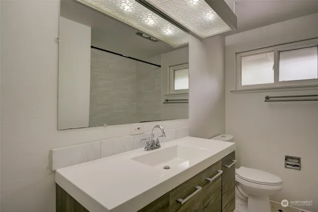 a bathroom with a sink a toilet and a mirror