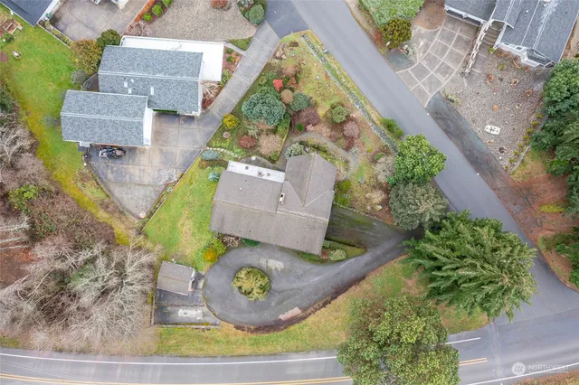 an aerial view of a house with a yard and a large tree