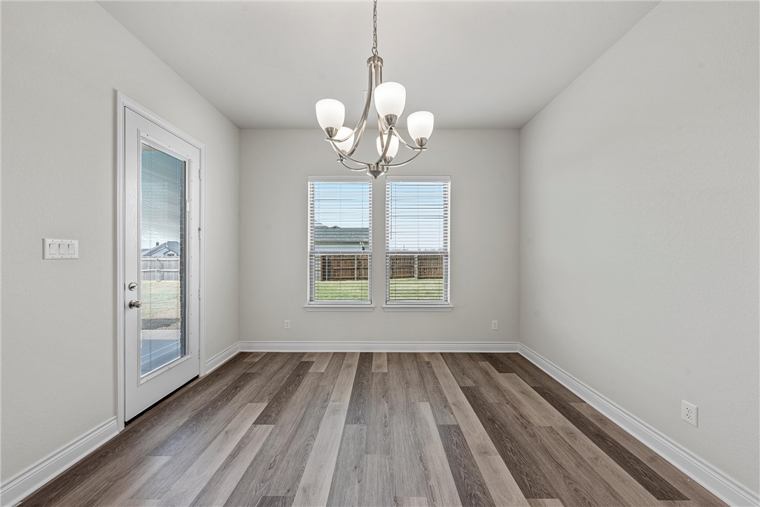 6402 Waggoner Court Temple, TX 76502 - Photo 11 of 30 a view of a room with wooden floor chandelier and window