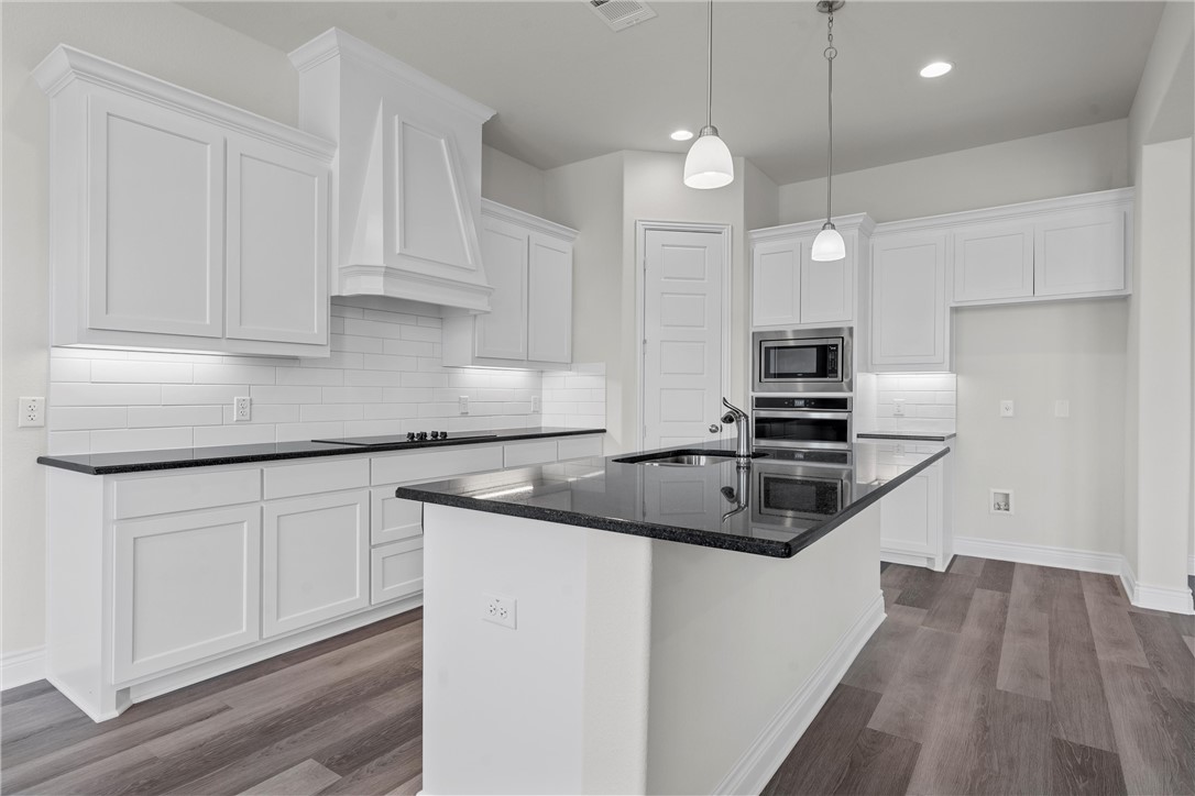 6402 Waggoner Court Temple, TX 76502 - Photo 8 of 30 a kitchen with granite countertop a sink a stove and cabinets