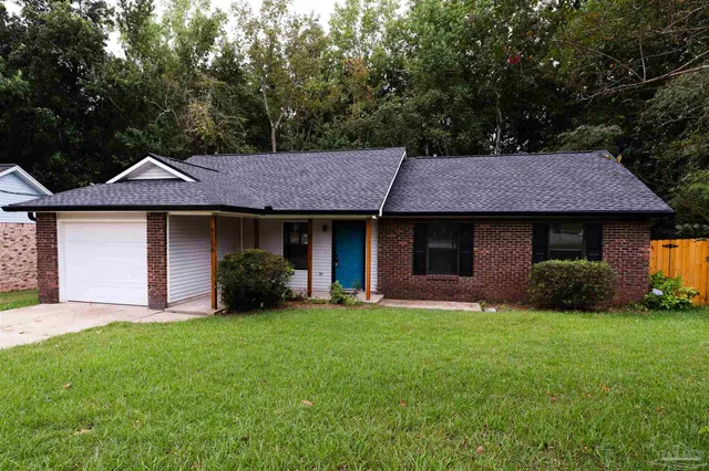 a front view of a house with a garden and yard