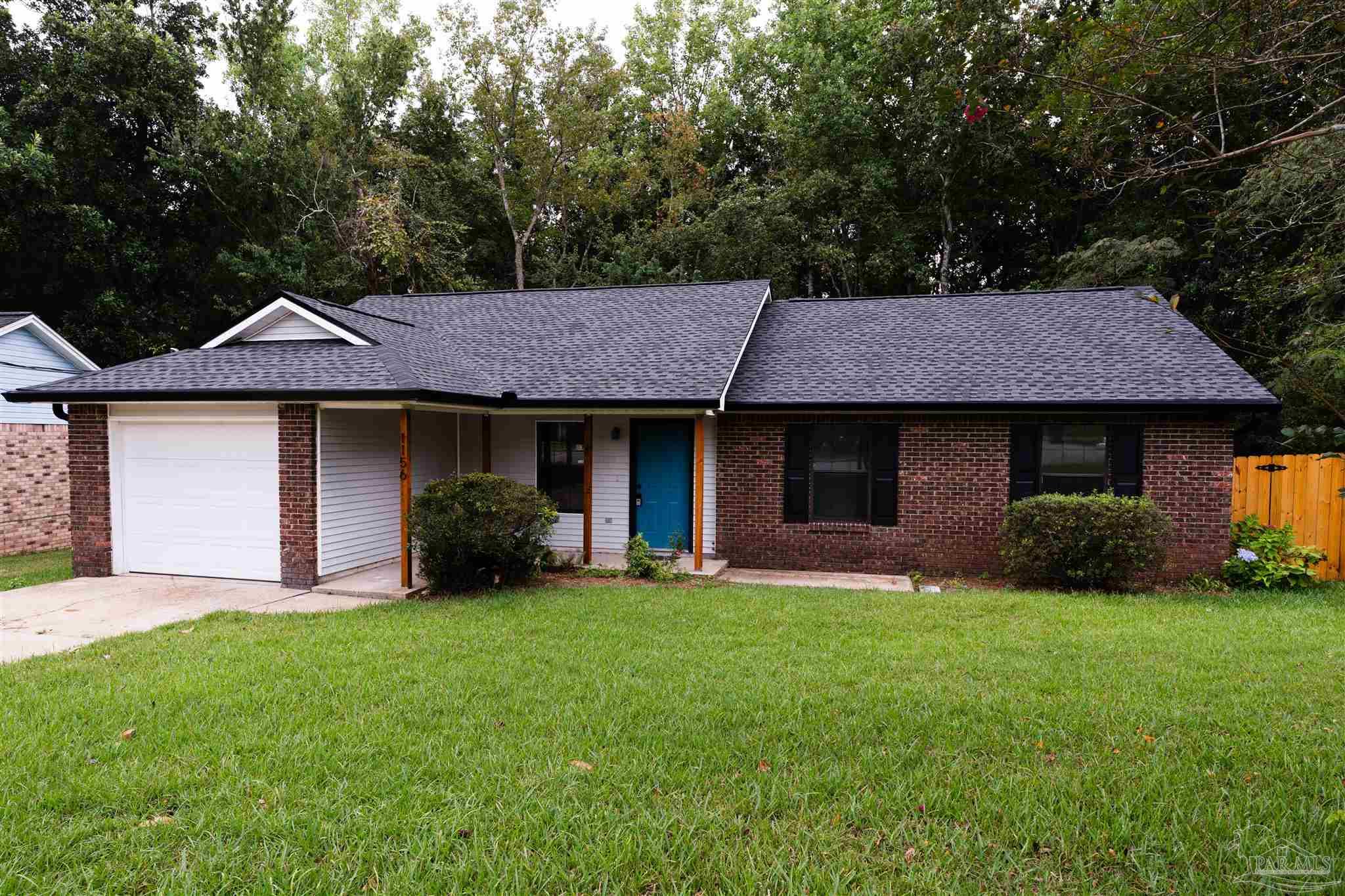 a front view of a house with a garden and yard