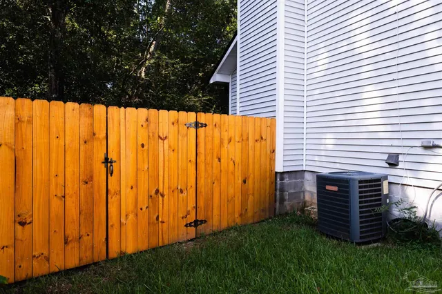 a view of a backyard with plants and wooden fence