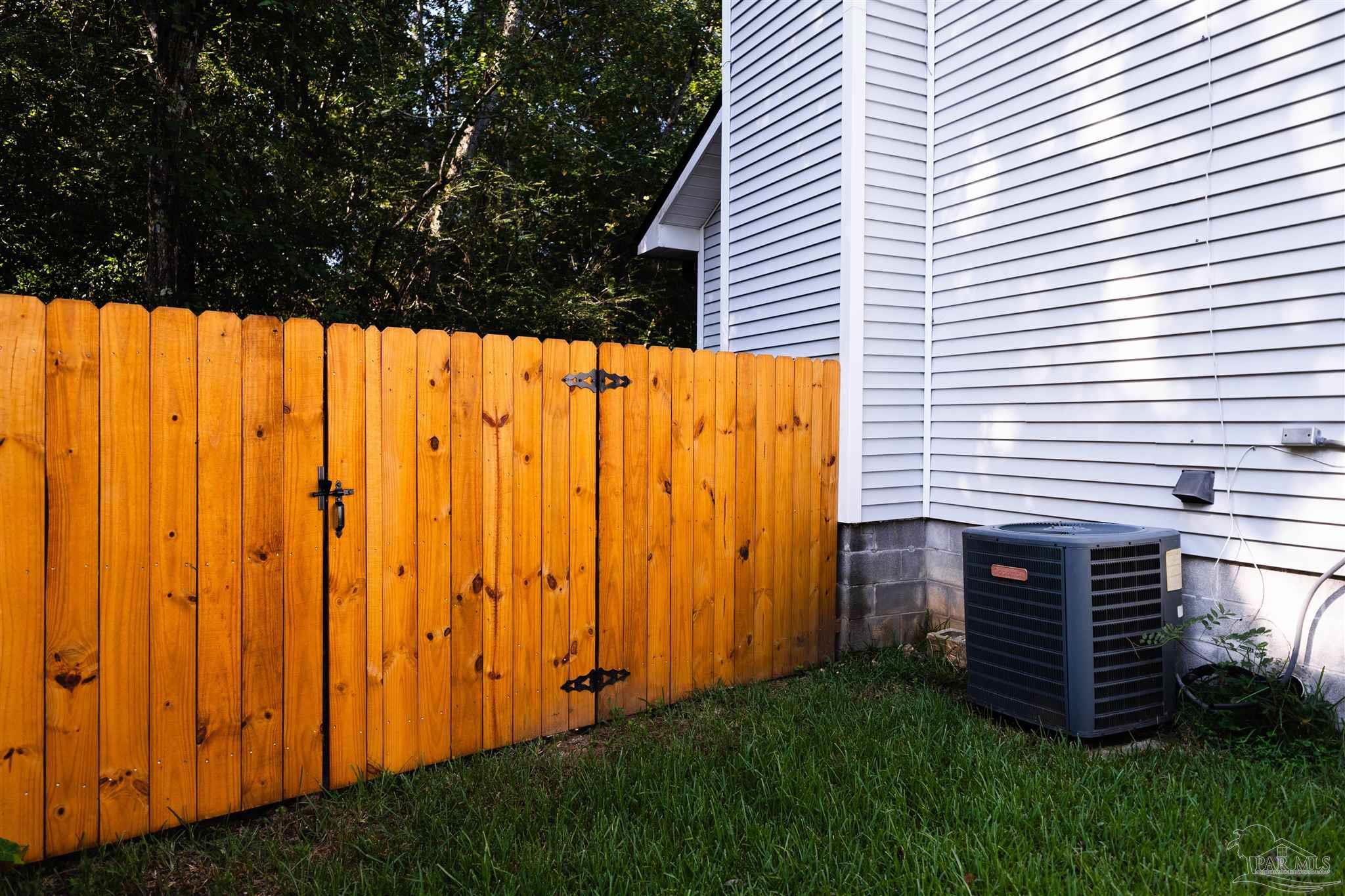 1156 Signal Hill Lane Pensacola, FL 32514 - Photo 13 of 16 a view of a backyard with plants and wooden fence