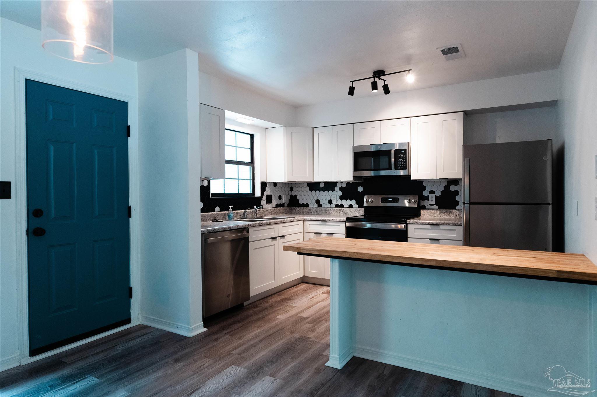 1156 Signal Hill Lane Pensacola, FL 32514 - Photo 3 of 16 a kitchen with a refrigerator and a stove top oven