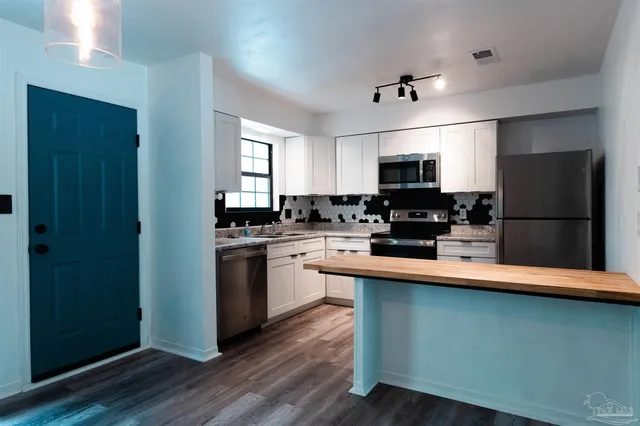 a kitchen with a refrigerator and a stove top oven