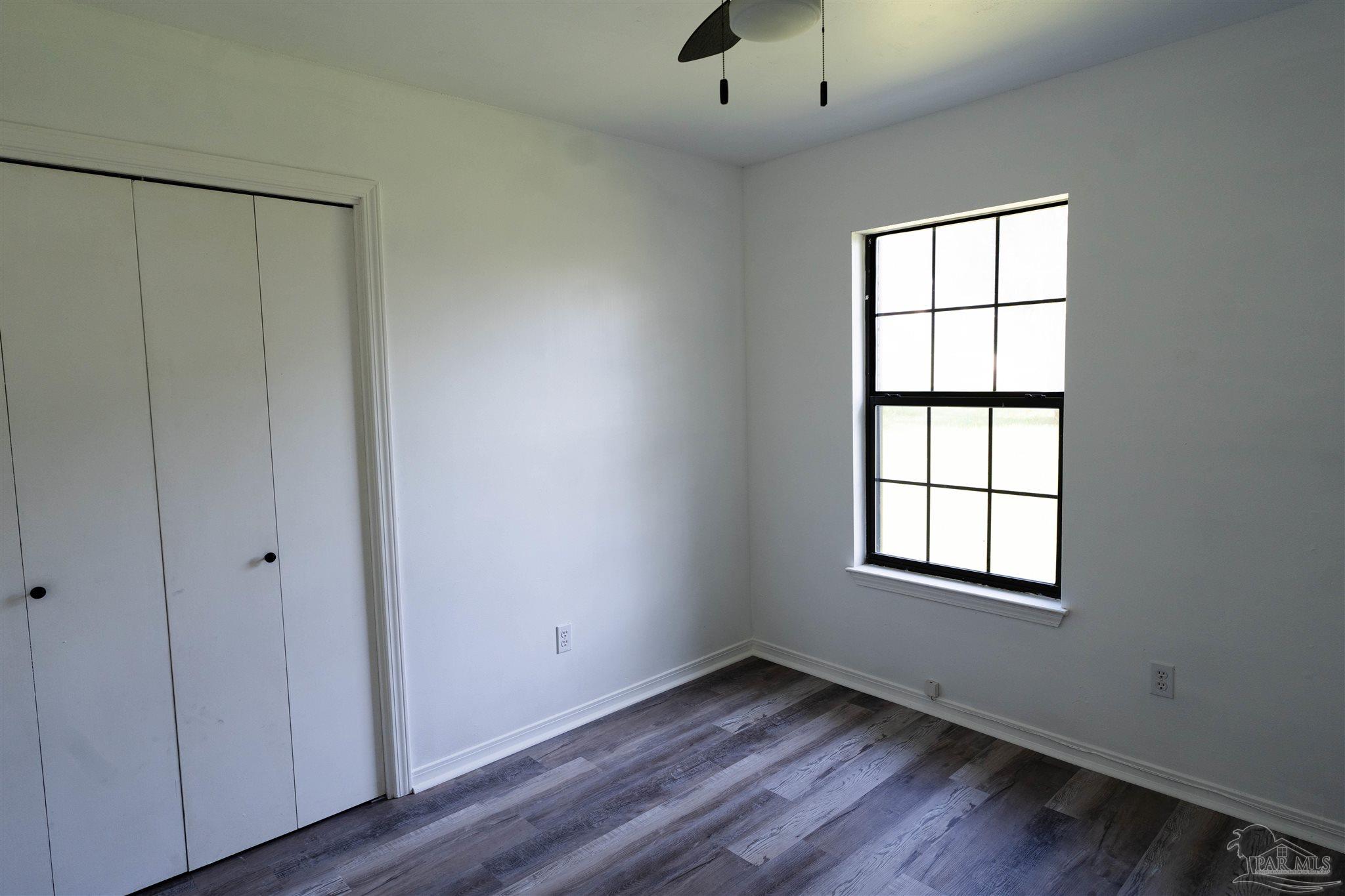 1156 Signal Hill Lane Pensacola, FL 32514 - Photo 5 of 16 an empty room with wooden floor closet and windows