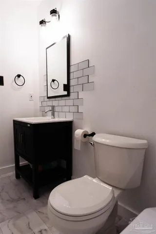 a bathroom with a toilet a sink and mirror