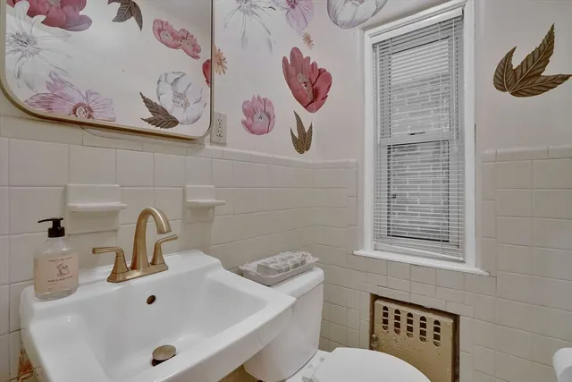 a bathroom with a sink and mirror with toilet