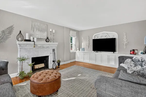 a living room with furniture a flat screen tv and a fireplace