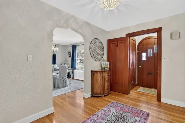 a view of a hallway with entryway wooden floor and front door
