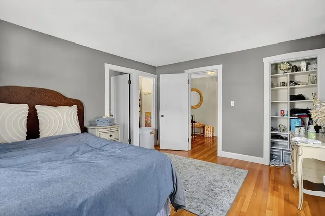 a bedroom with a large bed and wooden floor