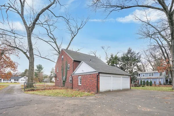 a front view of house with yard and trees around