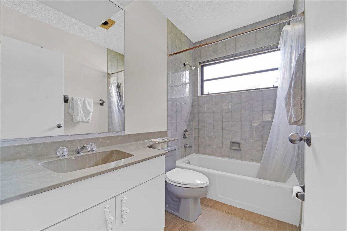 21575 Kapok Circle Boca Raton, FL 33433 - Photo 12 of 27 a bathroom with a granite countertop sink toilet and shower