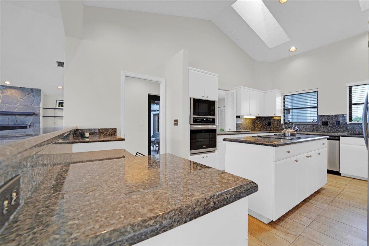 21575 Kapok Circle Boca Raton, FL 33433 - Photo 17 of 27 a kitchen with stainless steel appliances granite countertop a sink stove and refrigerator