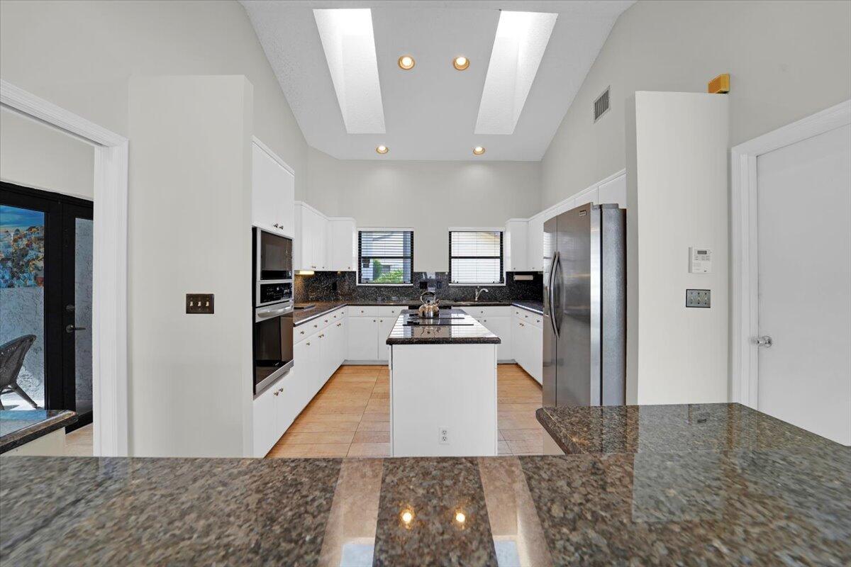 21575 Kapok Circle Boca Raton, FL 33433 - Photo 18 of 27 a large white kitchen with cabinets and stainless steel appliances