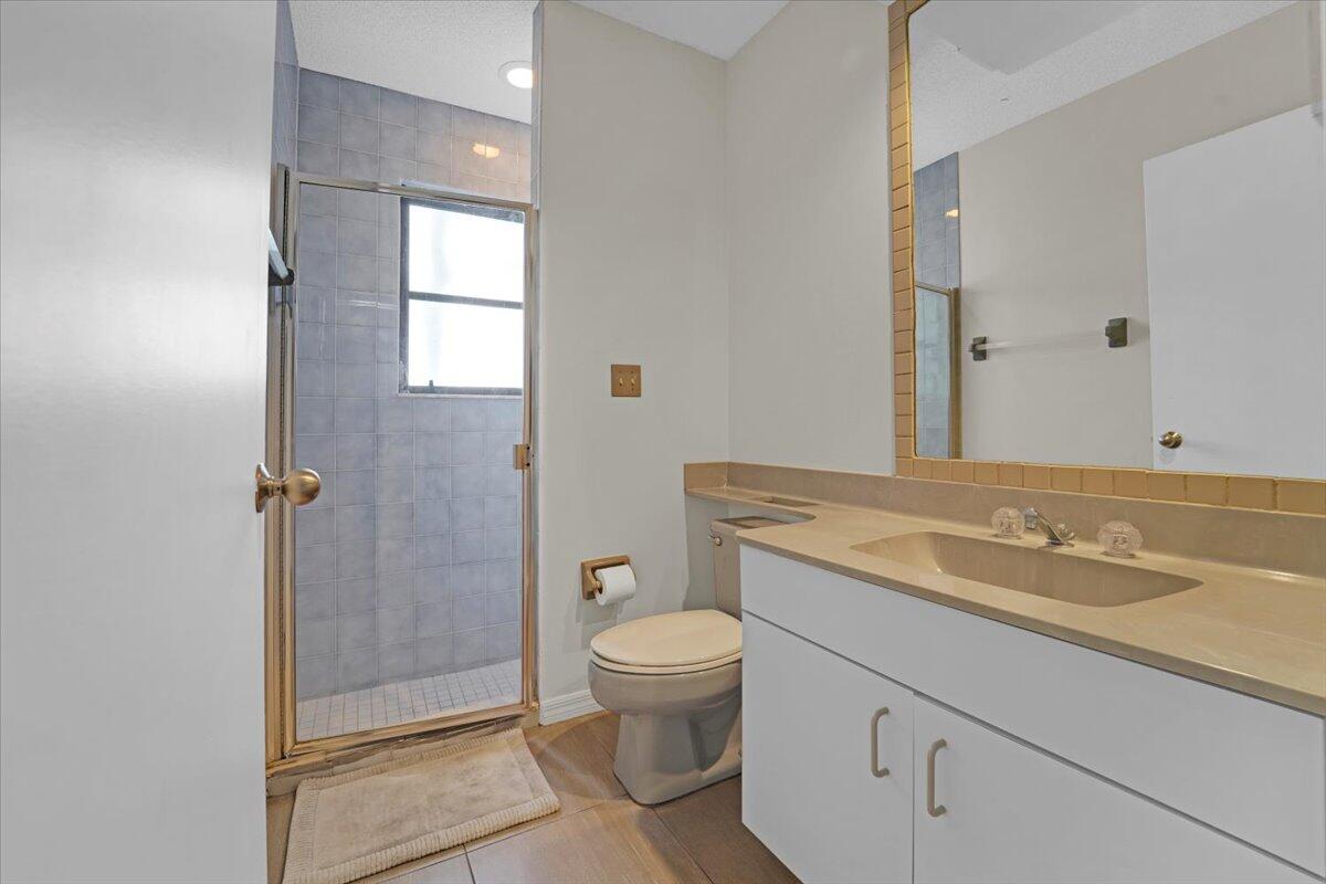 21575 Kapok Circle Boca Raton, FL 33433 - Photo 24 of 27 a bathroom with a granite countertop sink a toilet and shower
