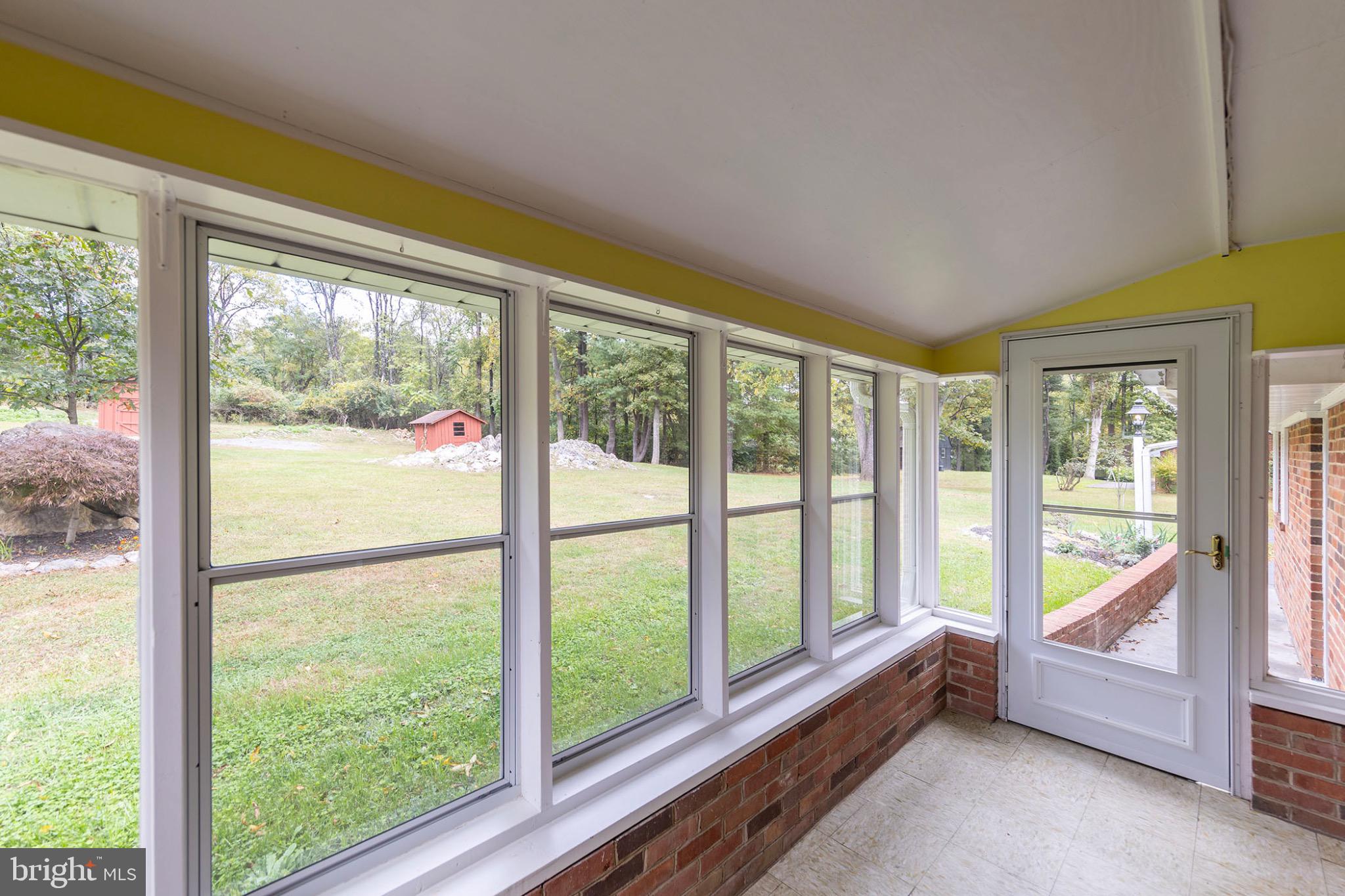 411 Rest Church Road Winchester, VA 22603 - Photo 17 of 46 Bright sunroom with scenic garden views.