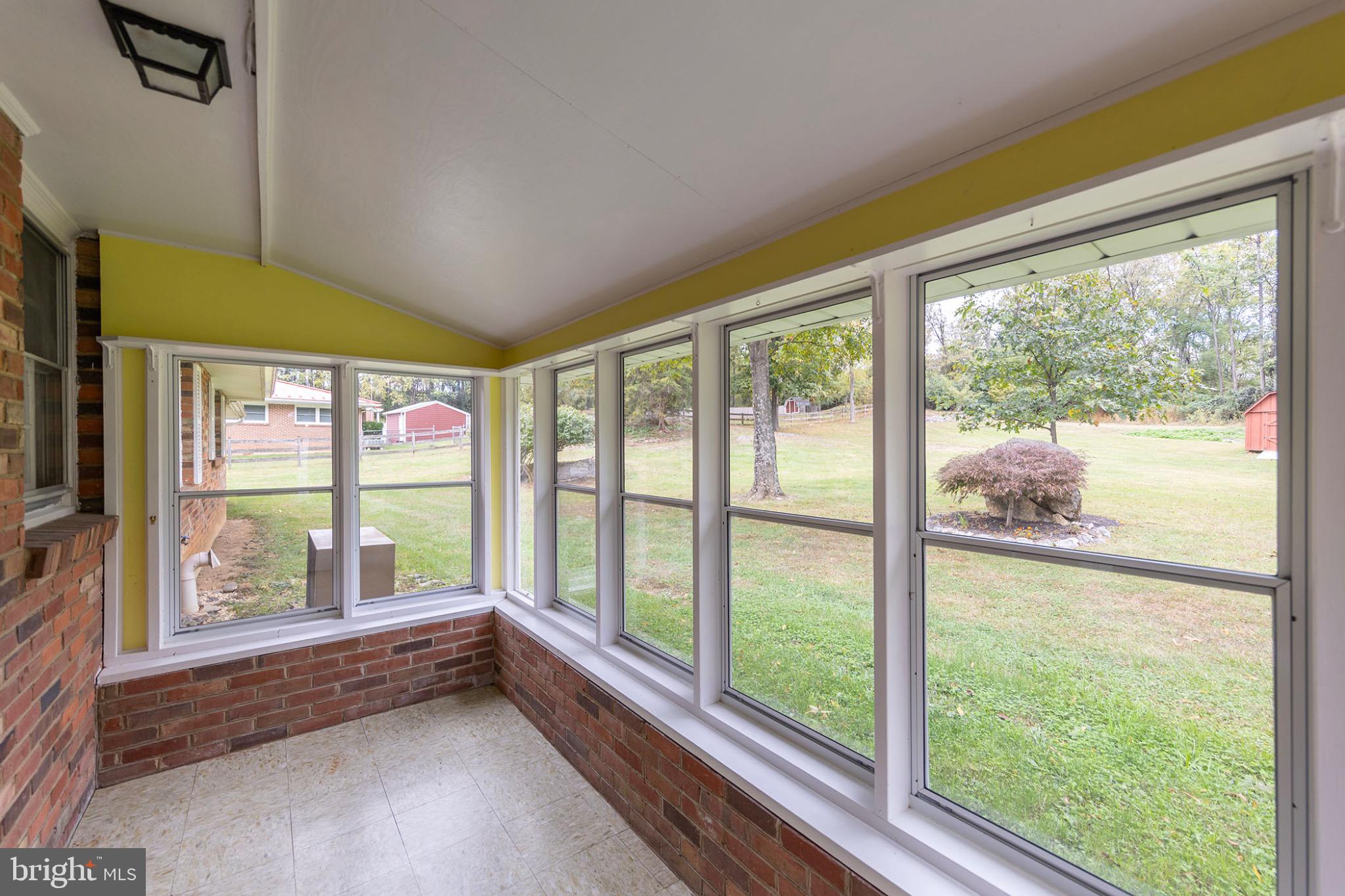 411 Rest Church Road Winchester, VA 22603 - Photo 18 of 46 Bright sunroom with scenic garden views.