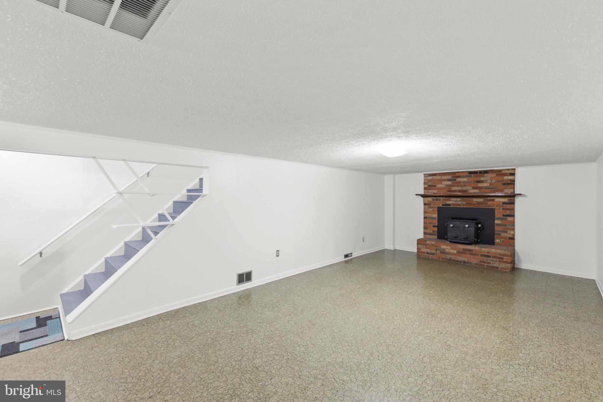 411 Rest Church Road Winchester, VA 22603 - Photo 29 of 46 Spacious basement with cozy fireplace charm.