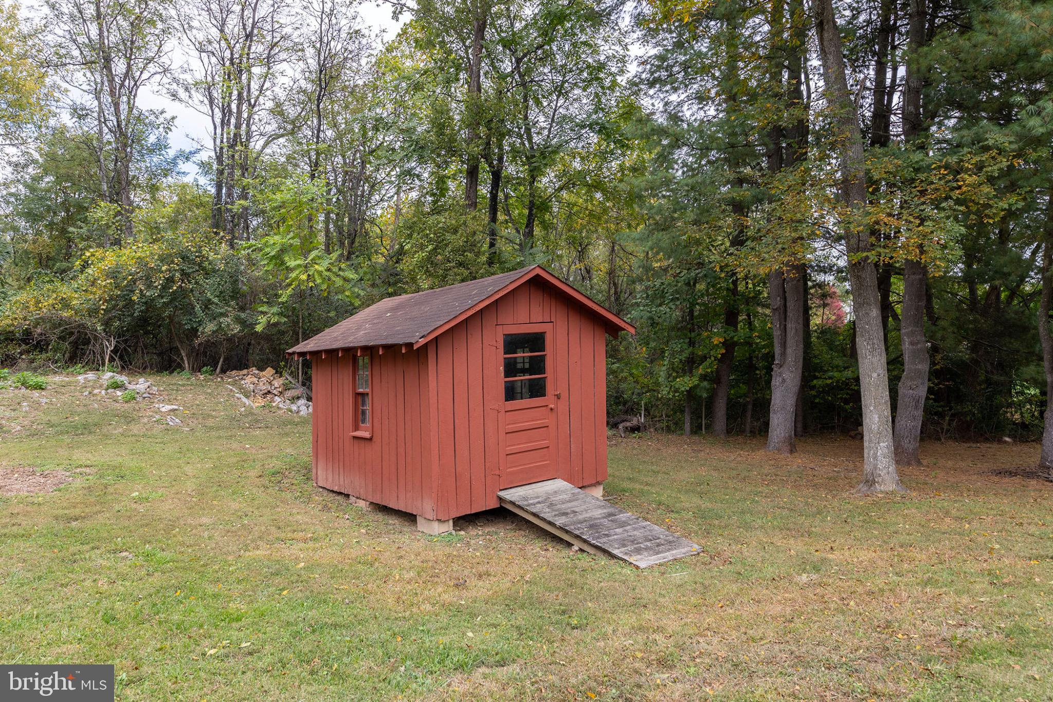 411 Rest Church Road Winchester, VA 22603 - Photo 42 of 46 Charming red shed nestled in serene woods.