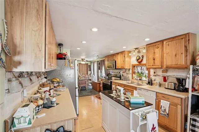 a kitchen with stainless steel appliances kitchen island granite countertop a sink and cabinets