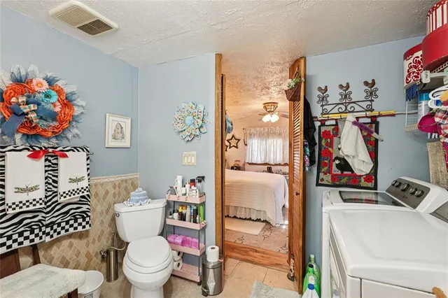 a bathroom with a toilet sink and shower curtain