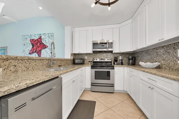 a kitchen with stainless steel appliances granite countertop a refrigerator and a sink