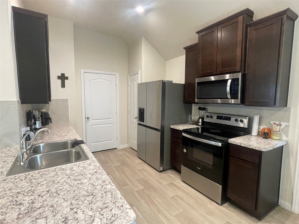 17768 Lion Heart Road Conroe, TX 77306 - Photo 4 of 11 a kitchen with granite countertop a refrigerator and a sink