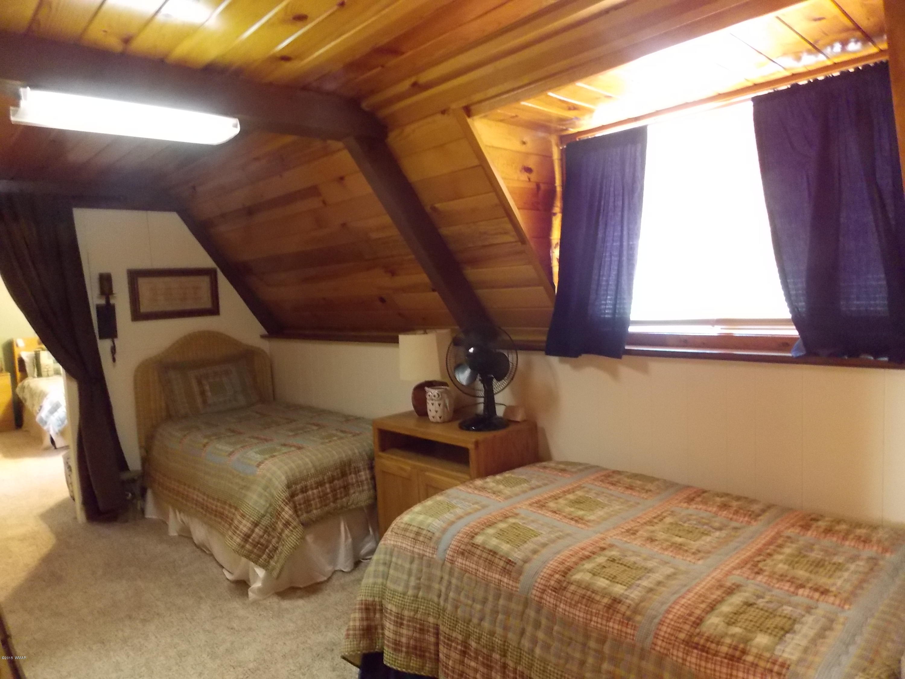 2886 Big Pine Road Overgaard, AZ 85933 - Photo 6 of 25 a bedroom with two beds and a window