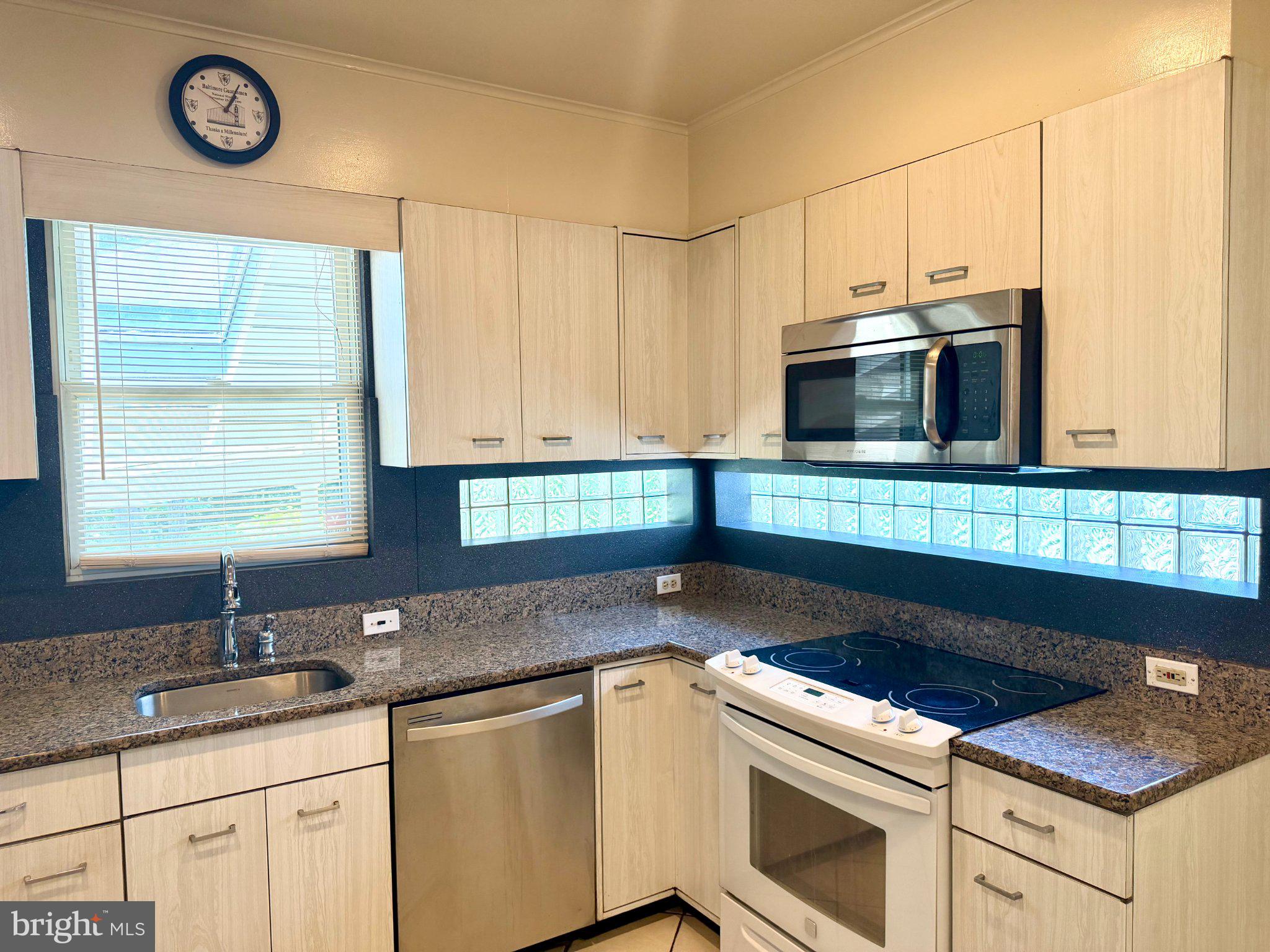 6318 Winner Avenue Baltimore, MD 21215 - Photo 20 of 75 a kitchen with stainless steel appliances granite countertop a sink stove and microwave