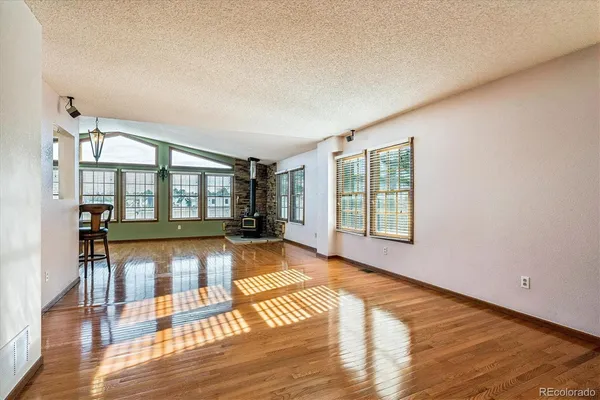 a view of empty room with windows and wooden floor