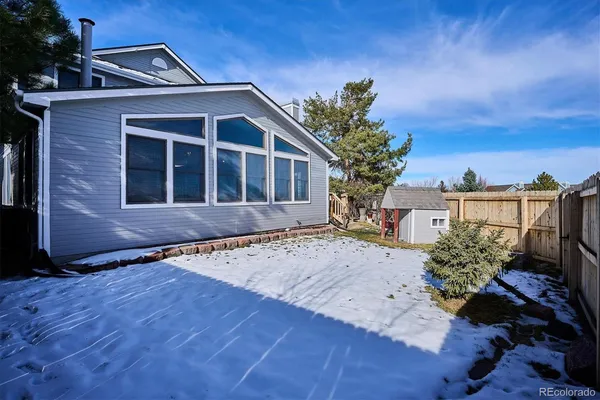 a view of backyard with wooden fence