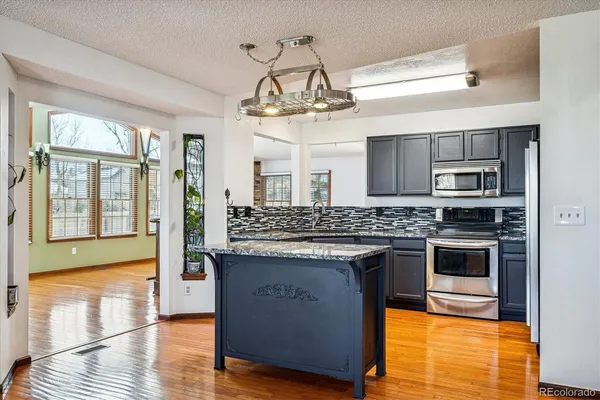 a kitchen with stainless steel appliances granite countertop a stove and a refrigerator