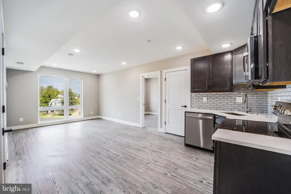 a large kitchen with stainless steel appliances granite countertop a stove a sink and a refrigerator