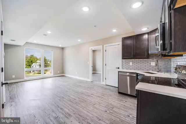 a large kitchen with stainless steel appliances granite countertop a stove a sink and a refrigerator