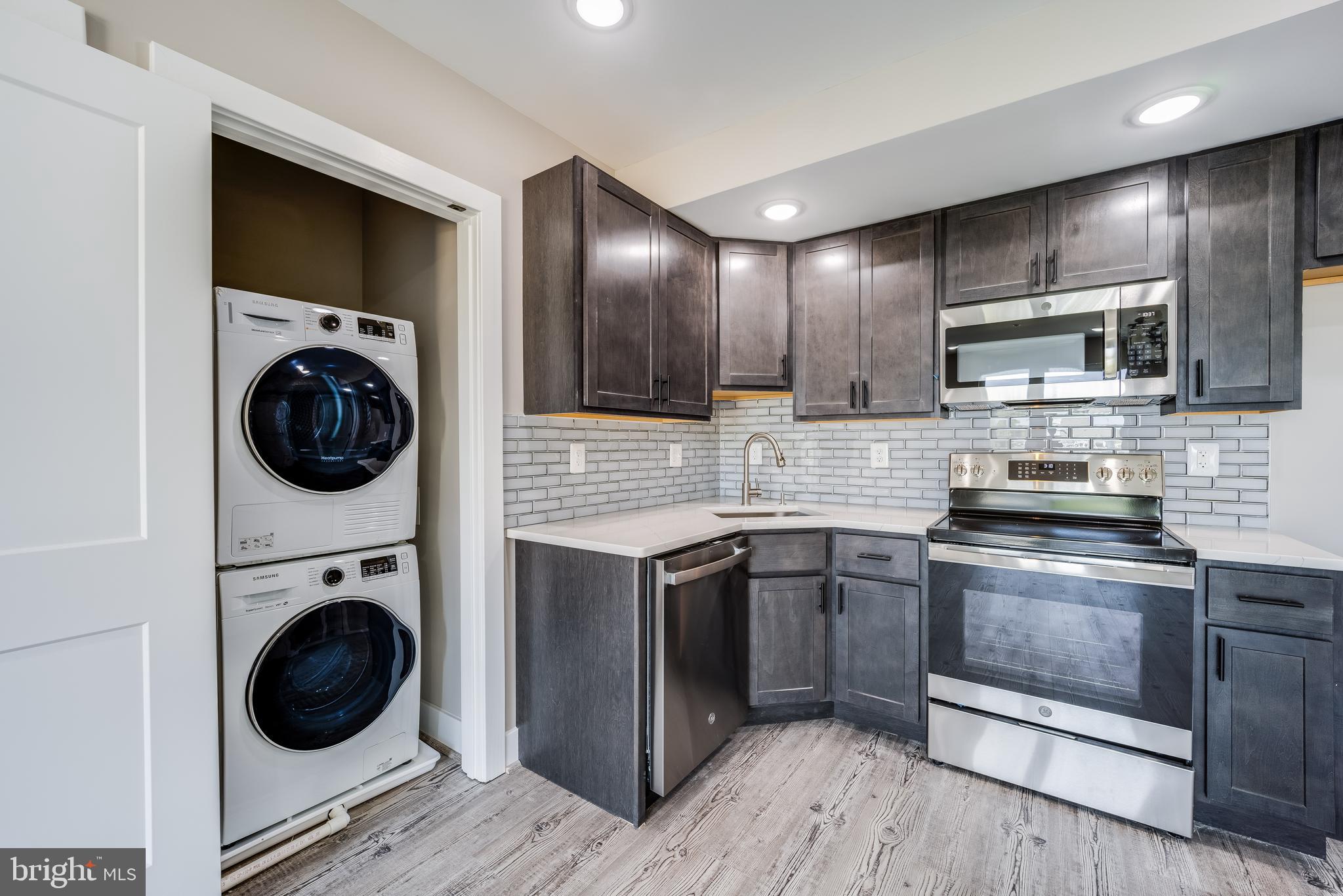 1617 Rhode Island Avenue Northeast, Unit 501 Washington, DC 20018 - Photo 7 of 17 a kitchen with stainless steel appliances granite countertop a stove a sink and a microwave