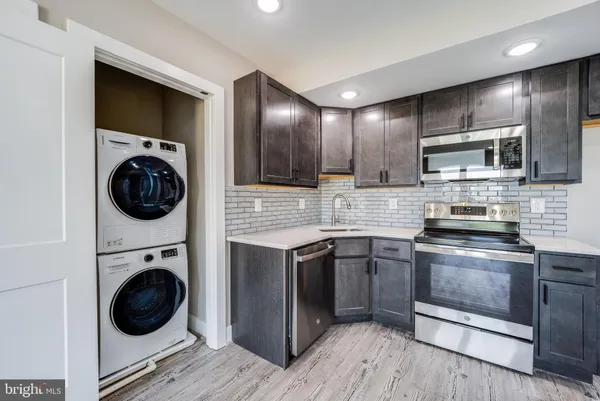 a kitchen with stainless steel appliances granite countertop a stove a sink and a microwave