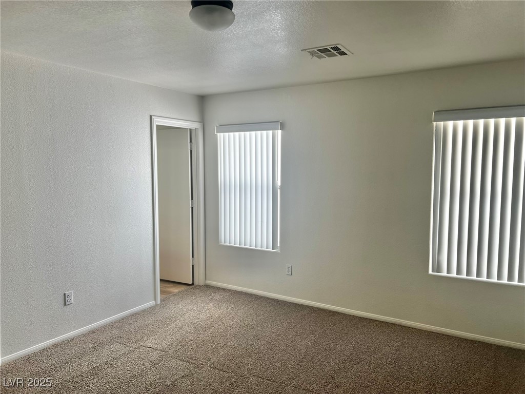 3153 Amari Avenue Las Vegas, NV 89141 - Photo 13 of 21 Carpeted spare room featuring baseboards and a textured ceiling