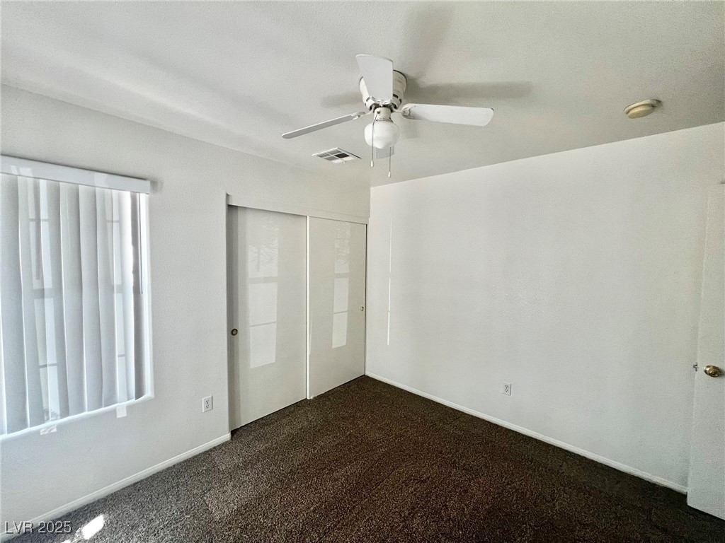 3153 Amari Avenue Las Vegas, NV 89141 - Photo 20 of 21 Unfurnished bedroom with a closet, dark carpet, and ceiling fan