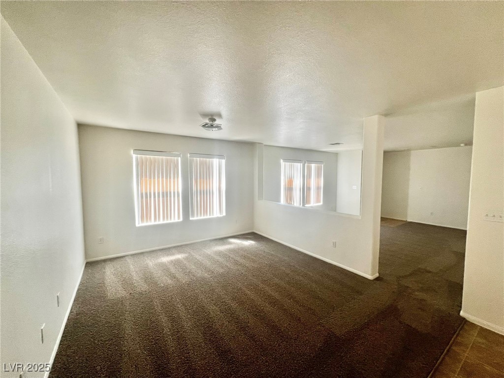 3153 Amari Avenue Las Vegas, NV 89141 - Photo 6 of 21 Empty room with dark carpet and a textured ceiling