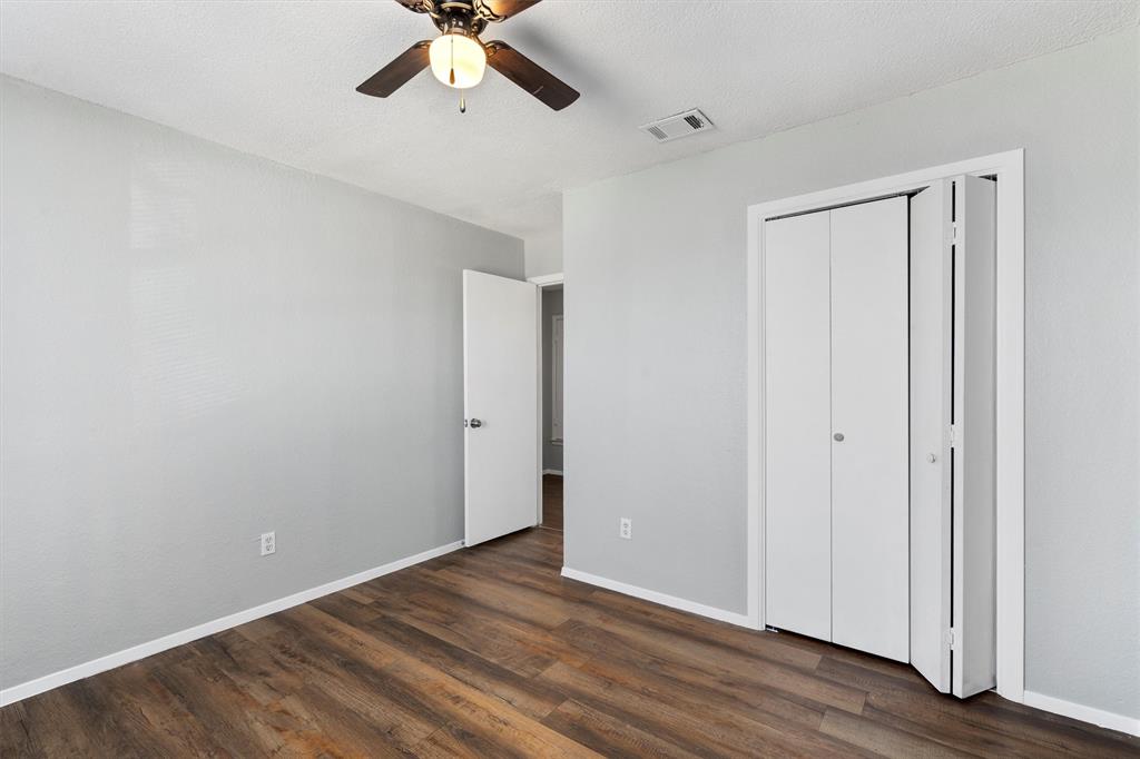 1711 Rawhide Loop Round Rock, TX 78681 - Photo 10 of 14 Unfurnished bedroom featuring dark wood-type flooring, a closet, and a ceiling fan
