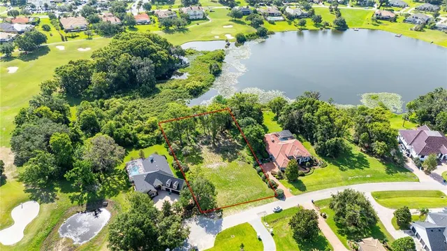 an aerial view of a house with a yard and lake view