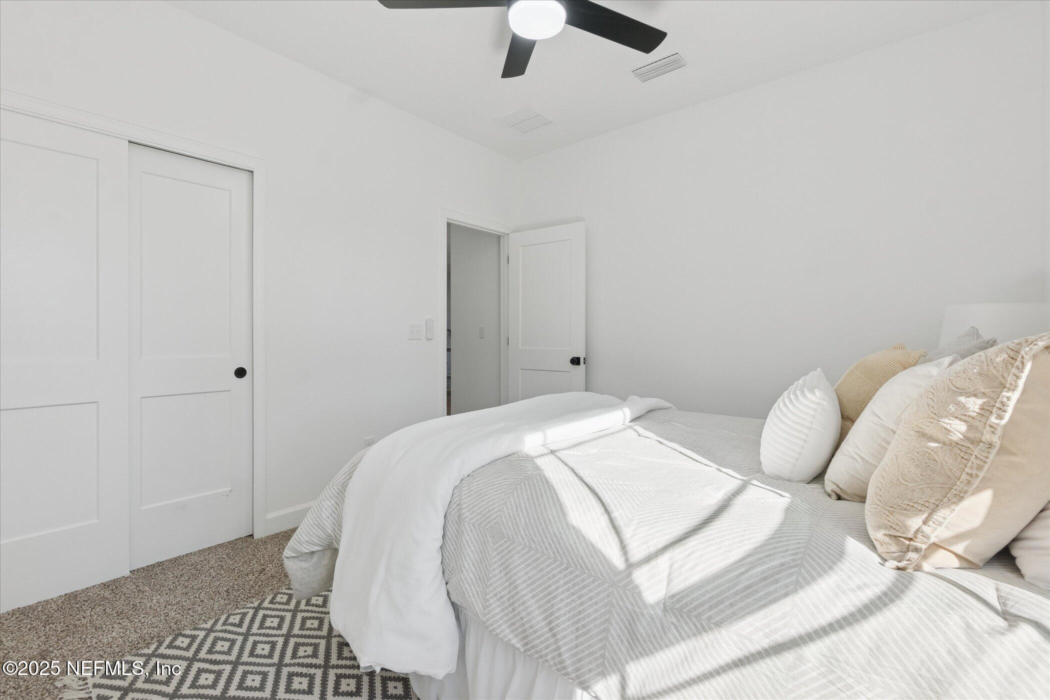 9293 Dolphin Street Sanderson, FL 32087 - Photo 20 of 29 a bedroom with a bed and a chandelier