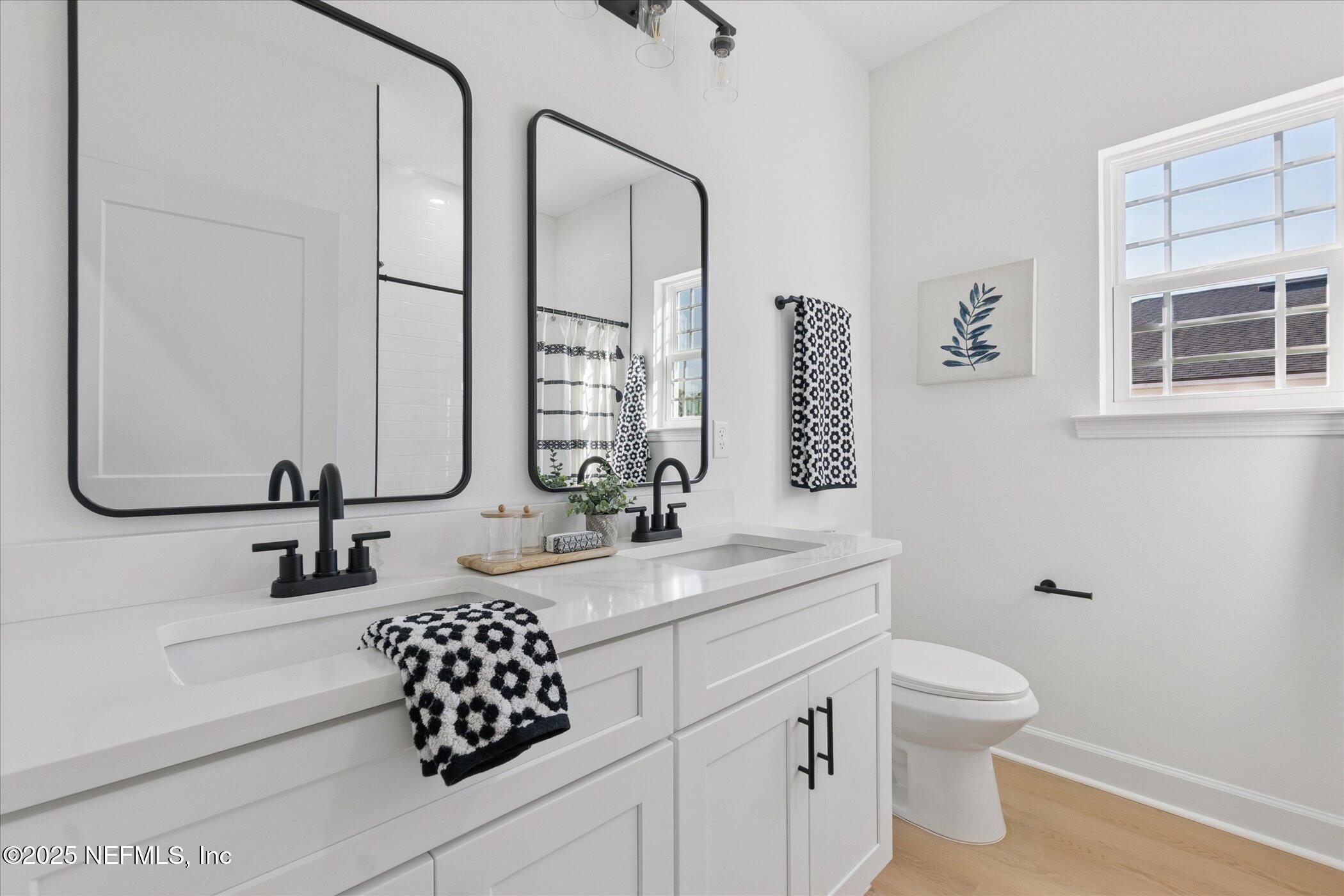 9293 Dolphin Street Sanderson, FL 32087 - Photo 23 of 29 a bathroom with a granite countertop sink mirror vanity and toilet