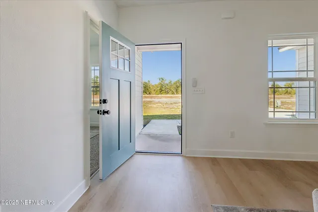 a view of hallway with wooden floor and a dining room