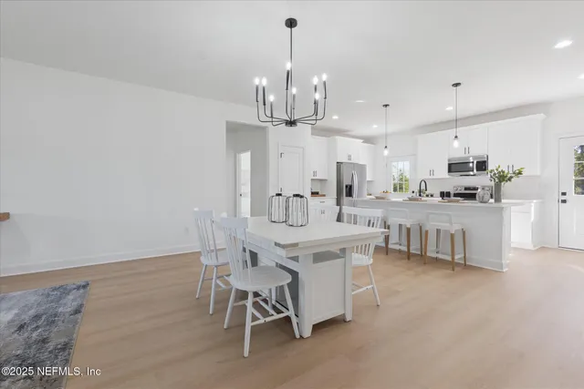a kitchen with kitchen island stainless steel appliances a dining table and chairs