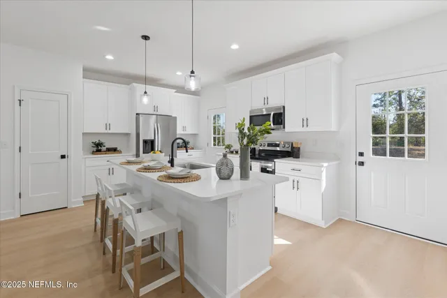 a kitchen with kitchen island a white counter top space cabinets and stainless steel appliances